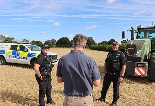 Two police officers in uniform walk outdoors